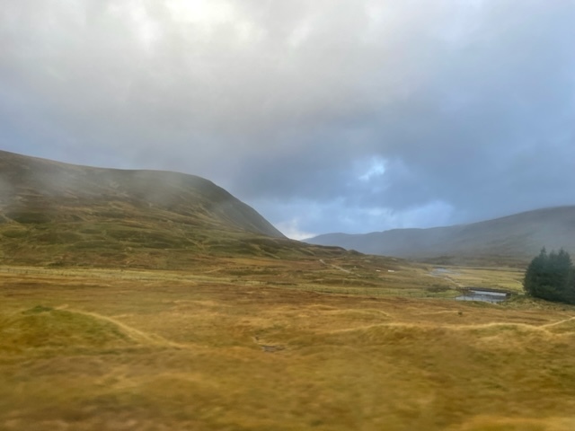view from a train window of empty-looking moorland