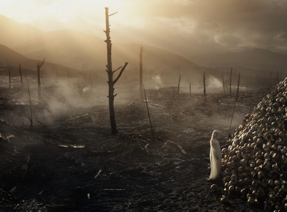 Battle aftermath Galadriel to the right putting a helmet onto a huge pile, with a scene of burned trees and devastation